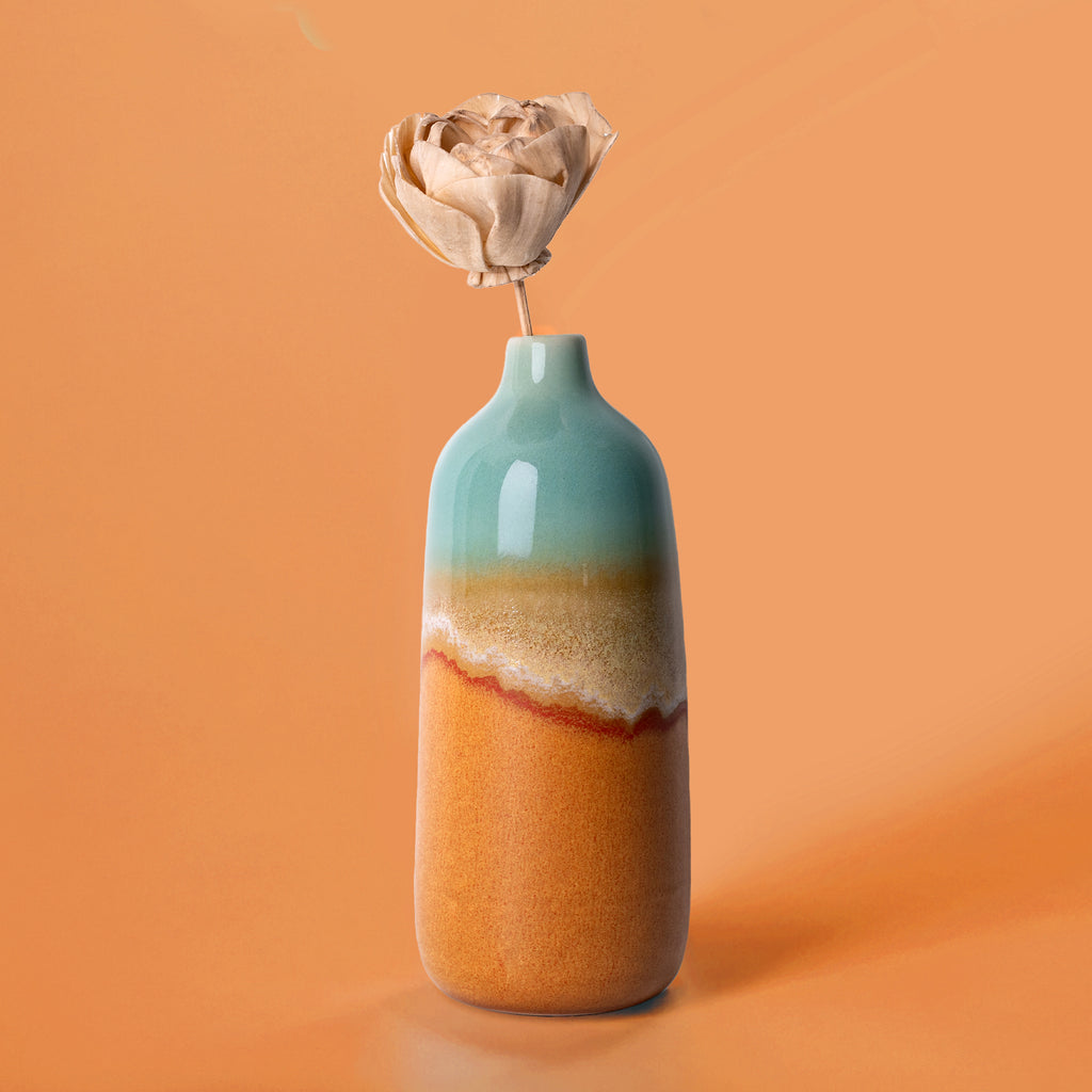 Pottery For The Planet eco-friendly home decor vase with blue and earthy tones holding a dried flower