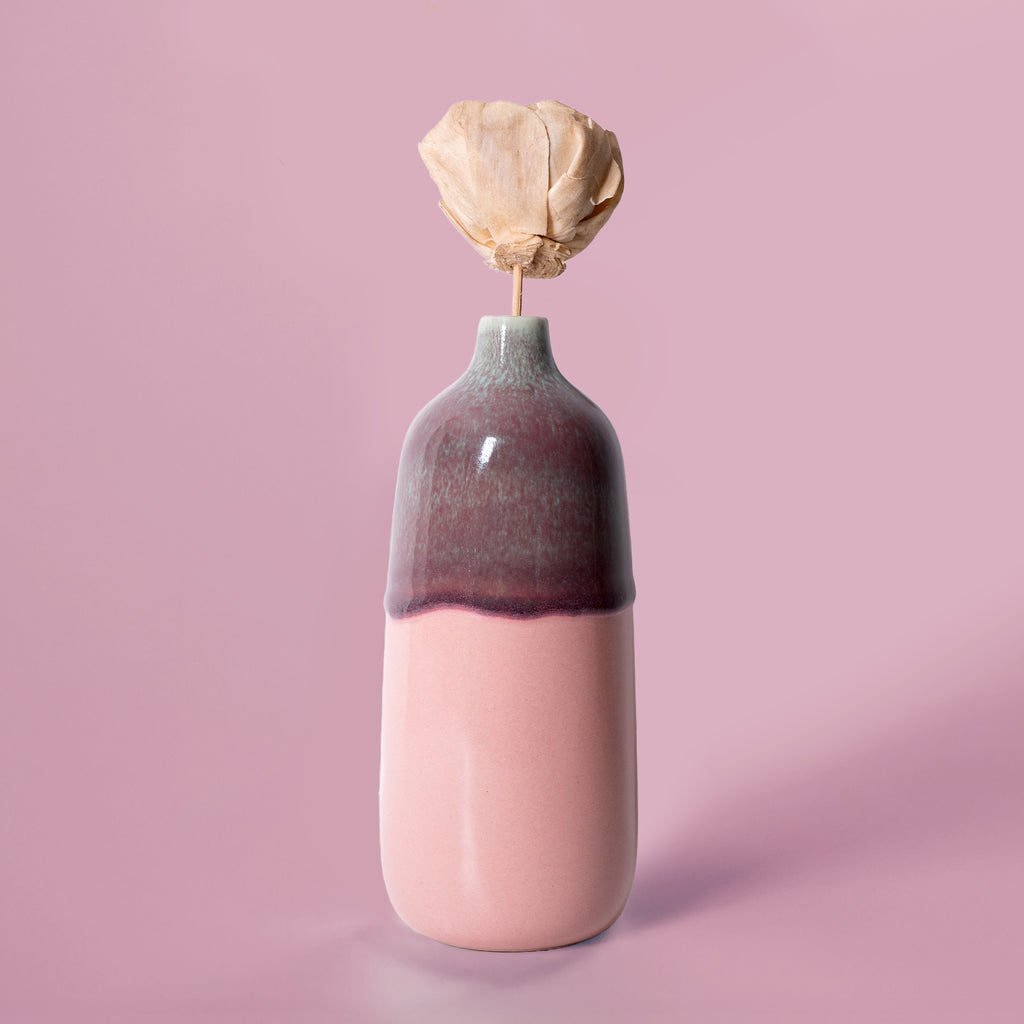 Pottery For The Planet eco-friendly home decor vase with pink and purple glaze holding a dried flower