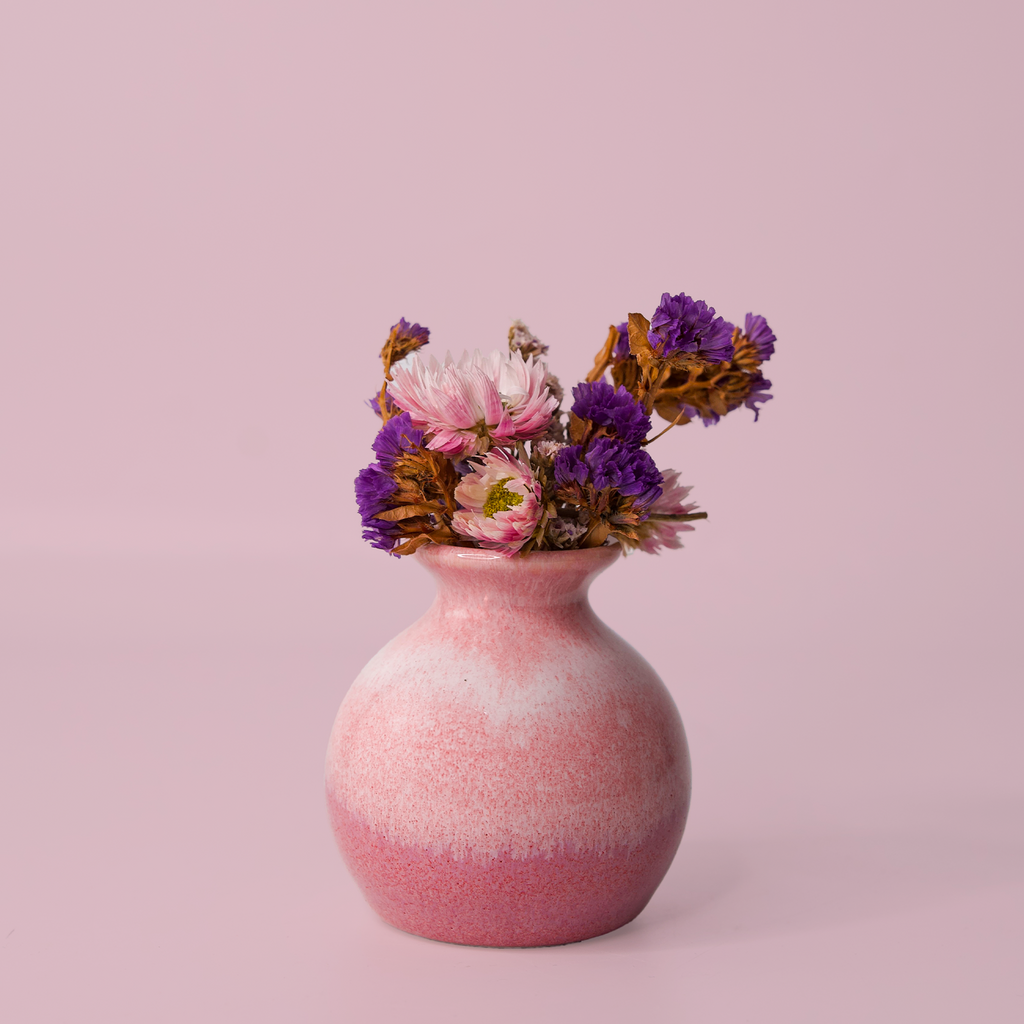 Pink eco-friendly home decor vase by Pottery For The Planet with dried purple and pink flowers