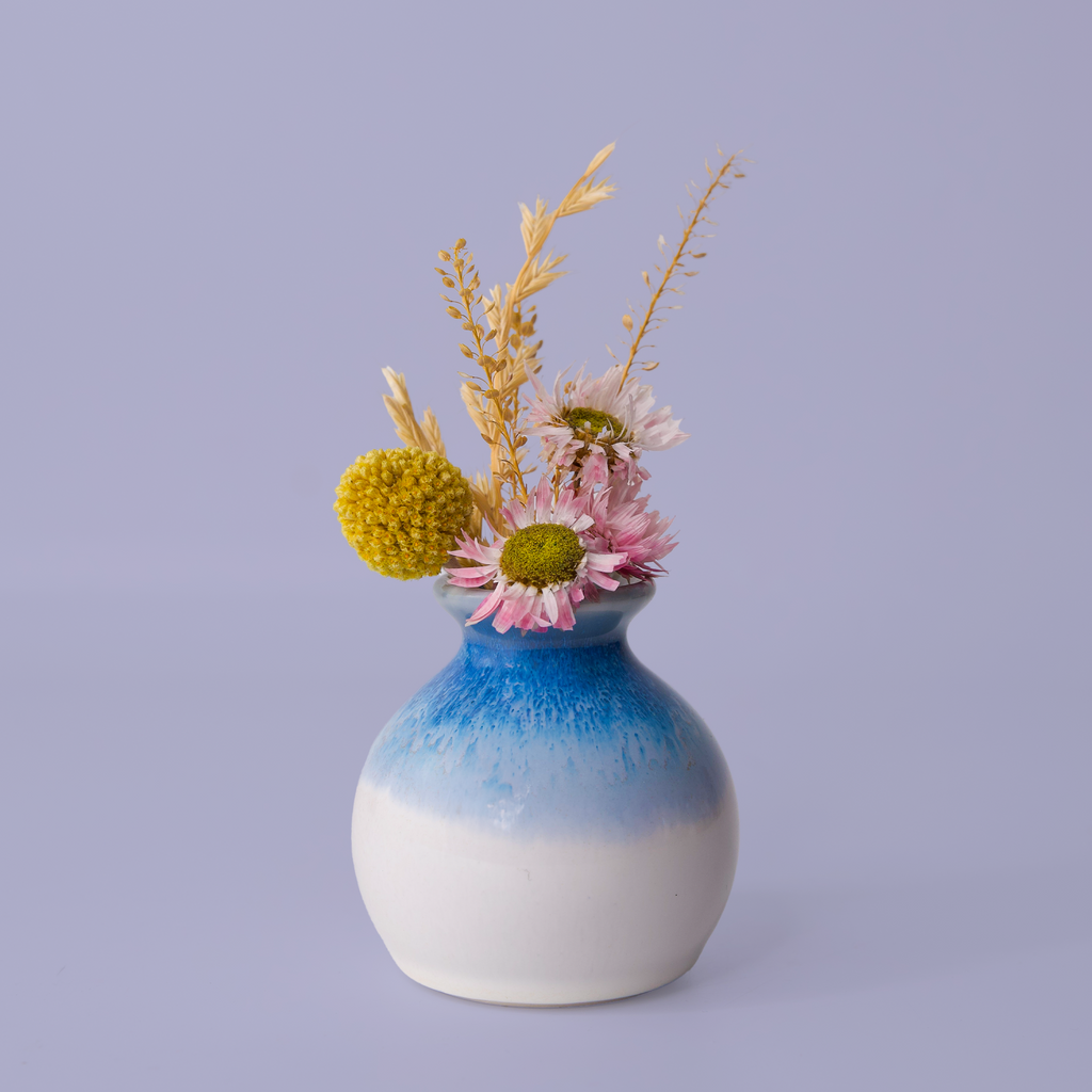 Eco-friendly home decor vase by Pottery For The Planet with blue and white glaze holding dried flowers