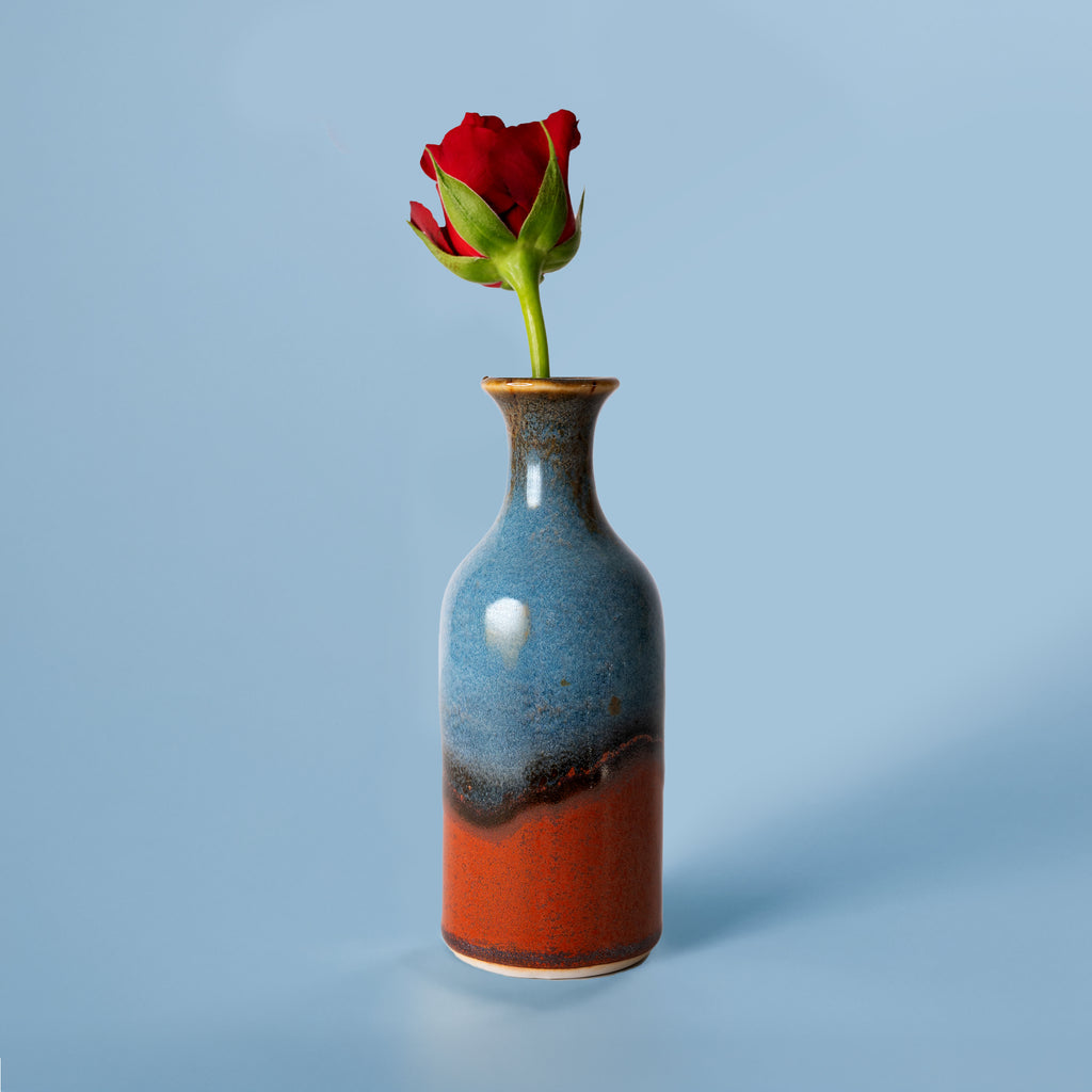 Pottery For The Planet small handmade flower vase in blue and terracotta with a single red rose