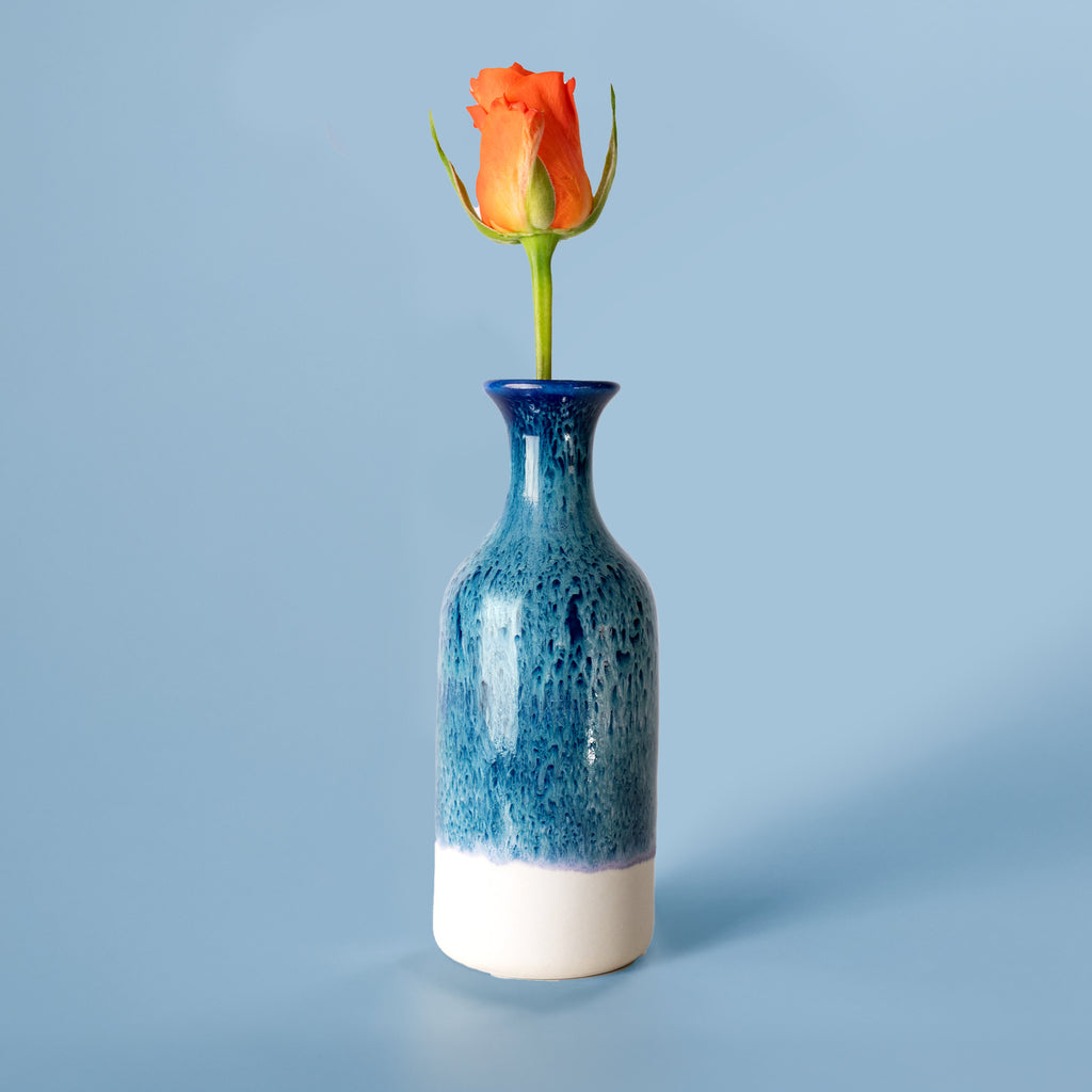 Blue and white ceramic small handmade flower vase by Pottery For The Planet with single orange rose