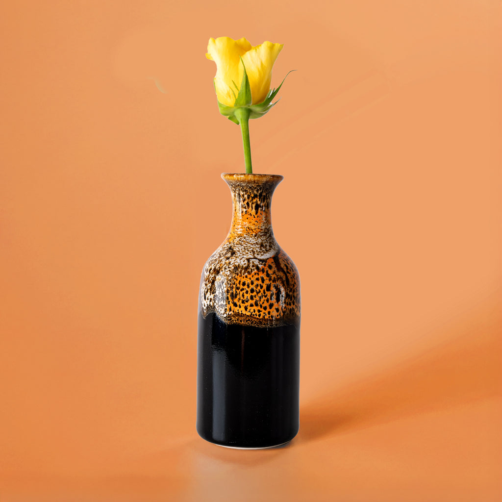Pottery For The Planet small handmade flower vase with black and brown glaze holding a yellow rose