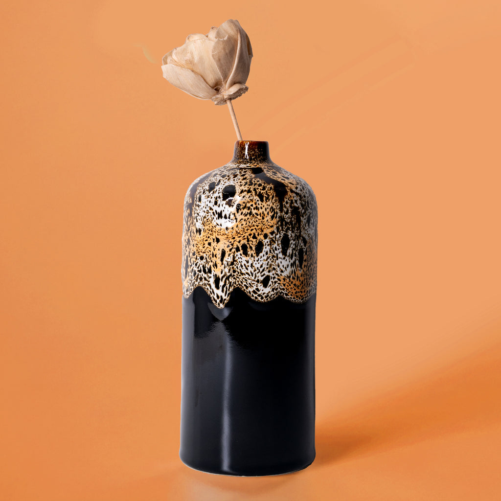 Pottery For The Planet medium decorative bud vase with black and gold textured finish holding a dried flower