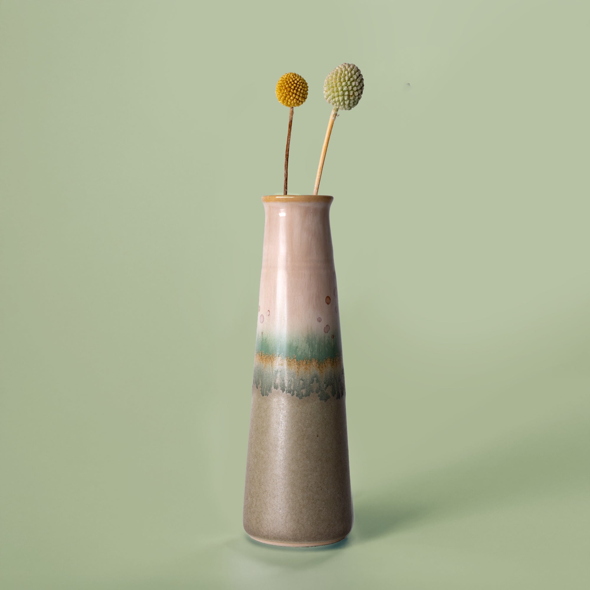 Pottery For The Planet ceramic sustainable home decor vase with green and beige glaze holding dried flowers