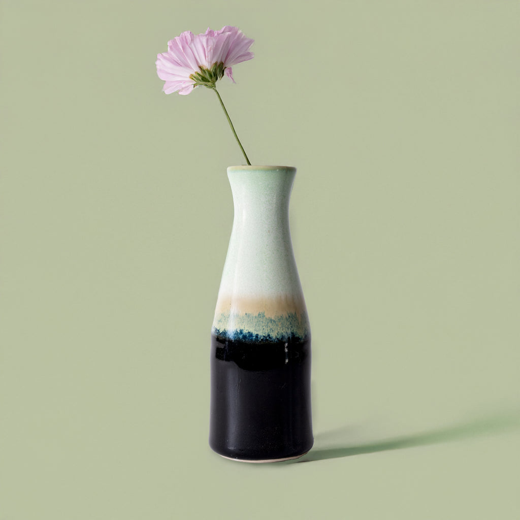 Unique ceramic flower vase by Pottery For The Planet with a gradient glaze holding a single pink flower