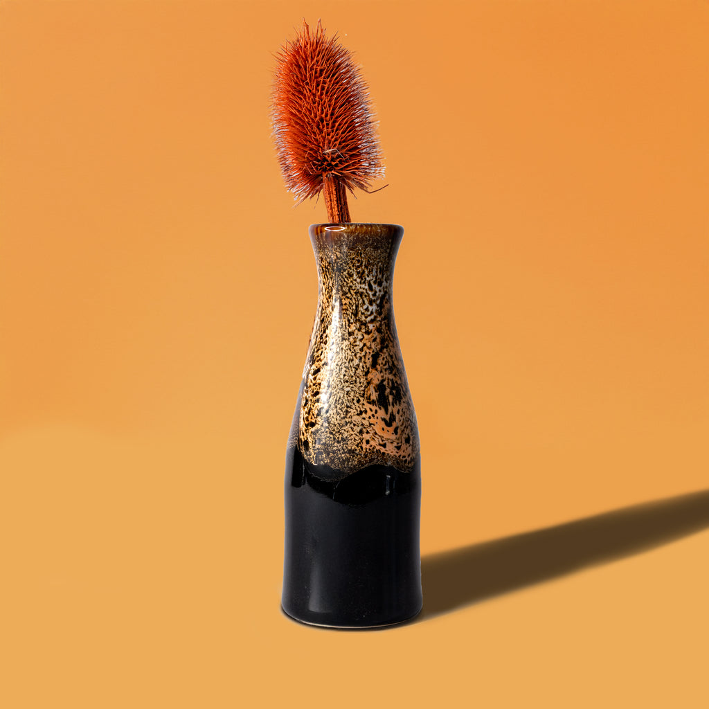Pottery For The Planet unique ceramic flower vase with black and speckled brown glaze holding a dried flower