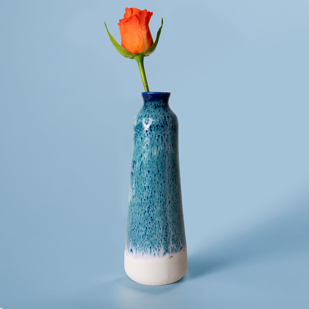 Unique handmade ceramic vase by Pottery For The Planet with blue glaze and orange rose