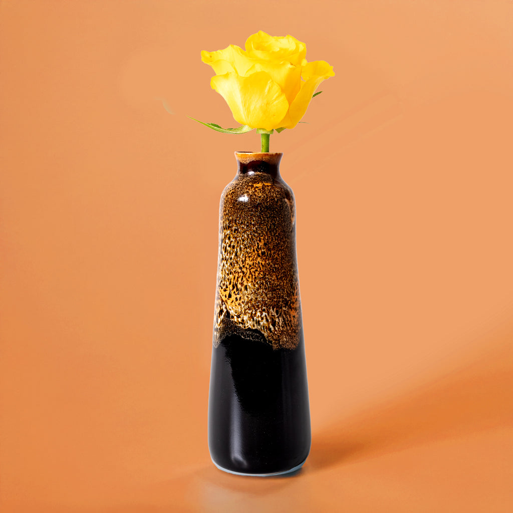 Unique handmade ceramic vase with glossy brown and black glaze holding a single yellow rose