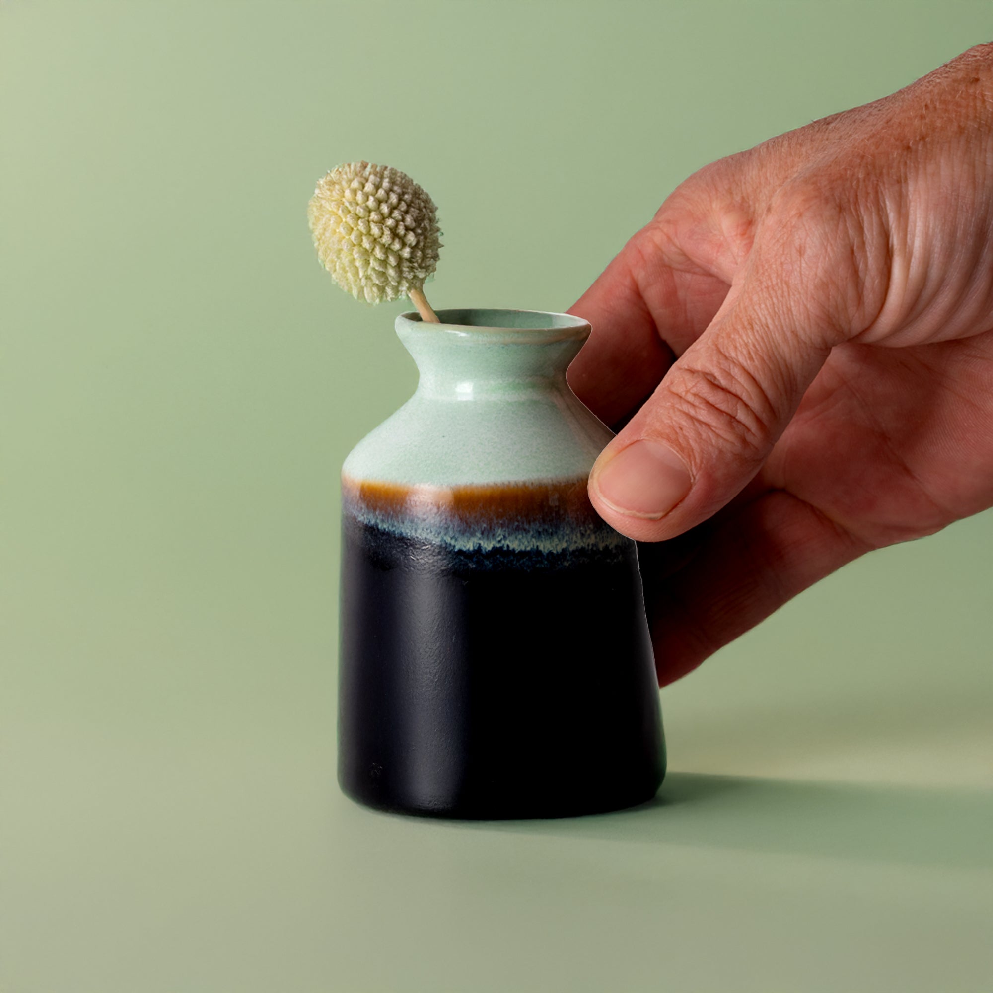 Miniature decorative vase for shelf by Pottery For The Planet in blue and black ceramic held by hand