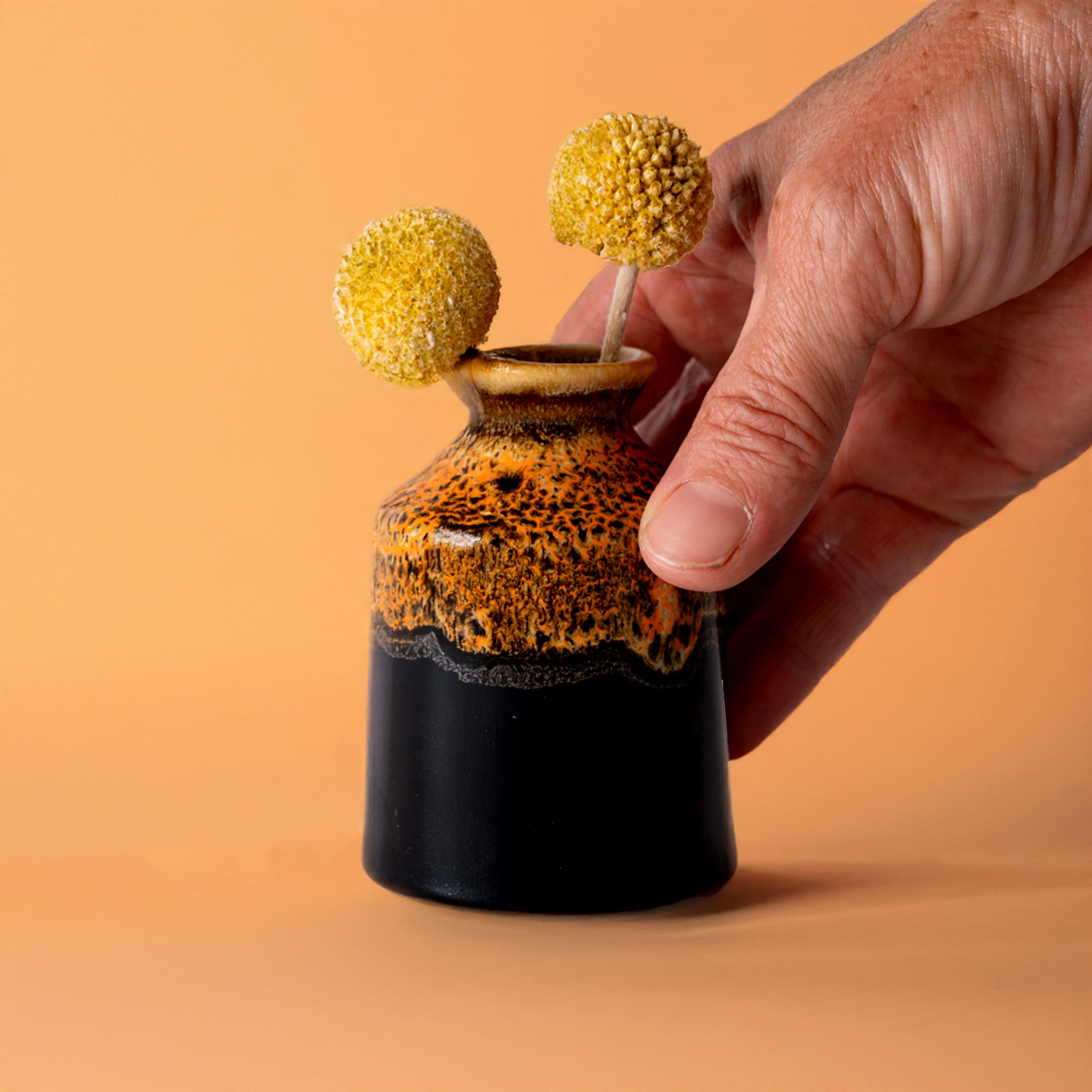 Pottery For The Planet miniature decorative vase for shelf with yellow craspedia flowers held by hand