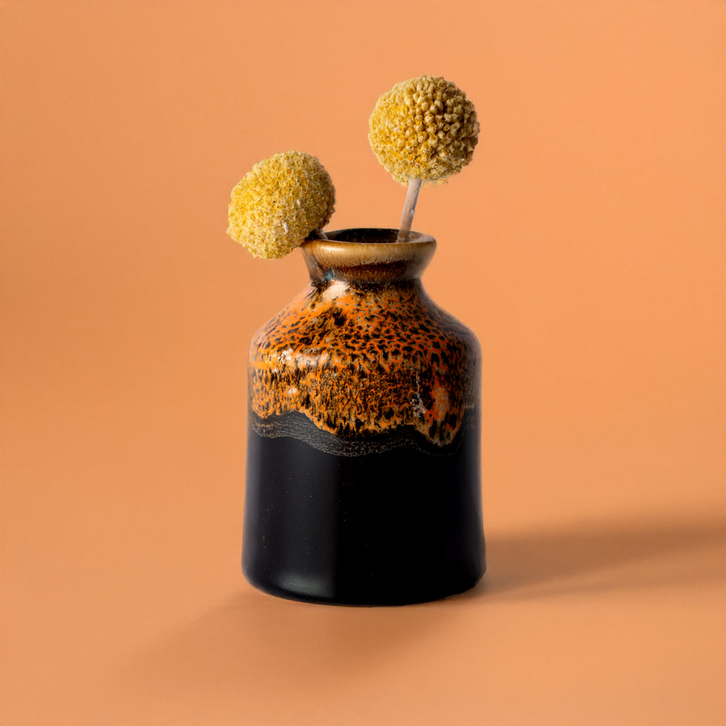 Pottery For The Planet miniature decorative vase for shelf with black and brown glaze holding yellow dried flowers