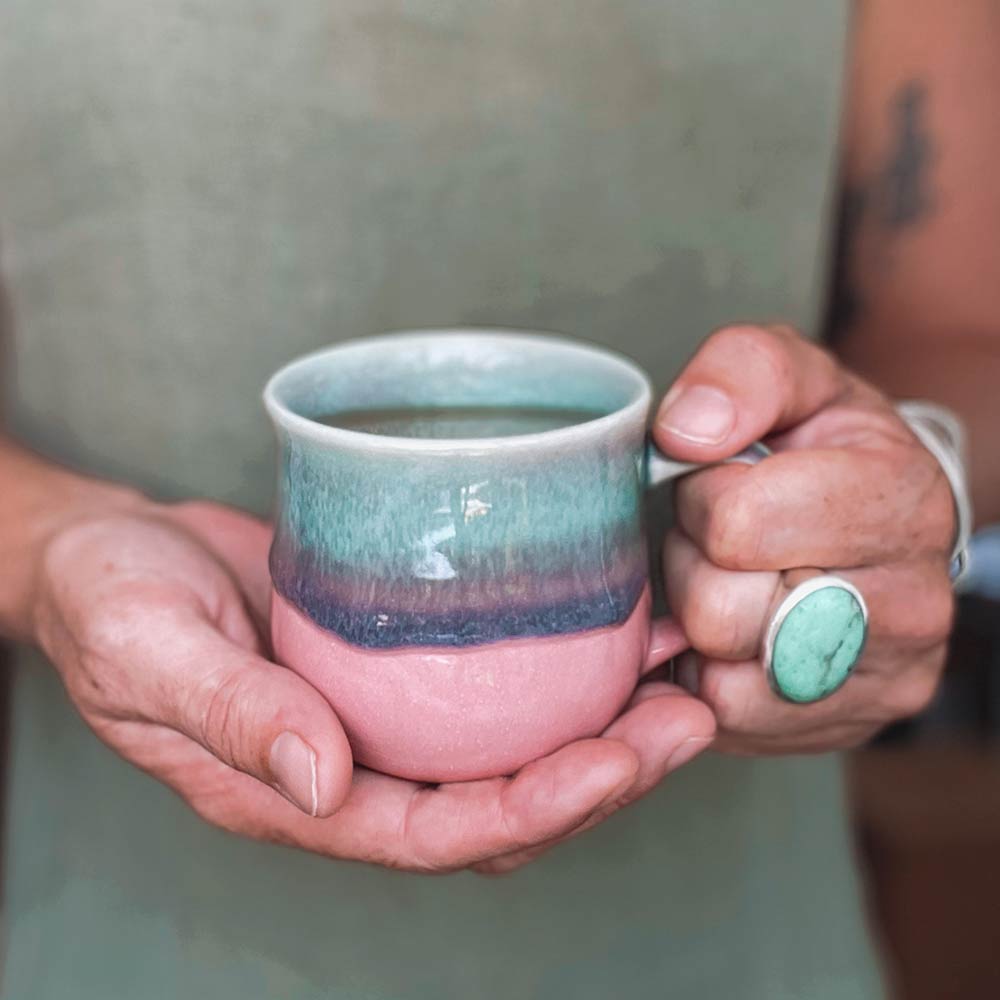 Pink and green mug in hand