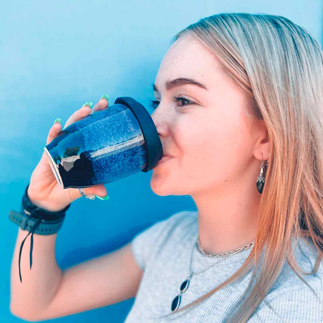 Girl drinking from Merlin Travel Cup